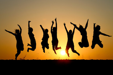 silhouette of friends jumping in sunset - 35478717