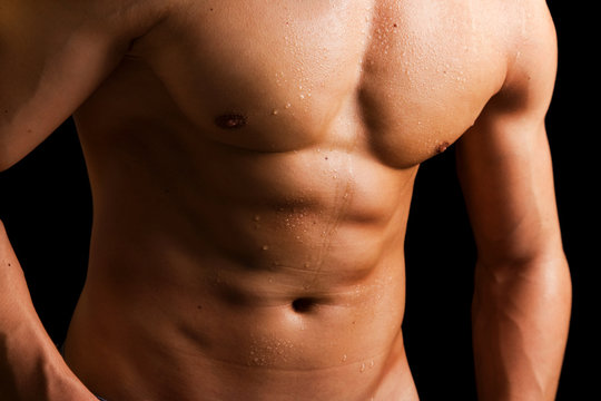 Man with beautiful naked muscled torso against black background