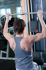 Naklejka premium Powerful muscular man lifting weights in gym