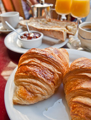 Breakfast with coffee and croissants in a basket on table