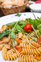 close-up of plate of pasta and chicken with lettuce