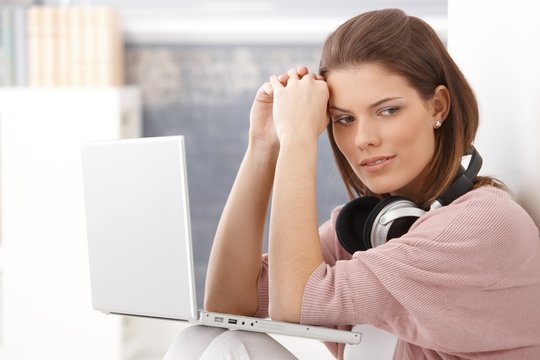 Young woman thinking, having laptop