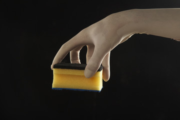 mano con guante de latex sujetando un estropajo en fondo aislado