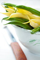 Yellow wax beans and green beans in a old white bowl