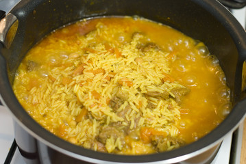 Rice, meat carrots and spices, cooking Uzbek pilaf.