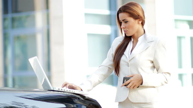 Attractive business woman using mobile phone and laptop