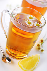 cup of herbal tea with chamomile flowers and lemon