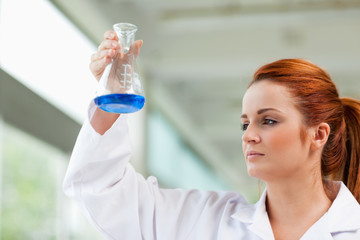 Scientist looking at a blue liquid