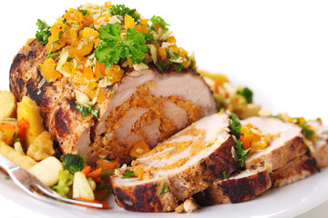 Stuffed pork roast with dried apricots and nuts on white backgro