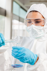 Portrait of a protected female scientist pouring liquid