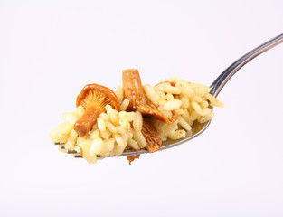 Risotto with mushrooms on a fork on white