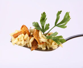 Risotto with mushrooms decorated with parsley on a fork