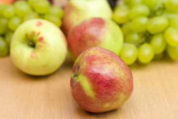 Fresh fruits, apples, grapes and peaches on the table