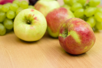 Fresh fruits, apples, grapes and peaches on the table