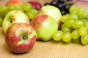 Fototapeta na wymiar Fresh fruits, apples, grapes and peaches on the table