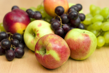 Fresh fruits, apples, grapes and peaches on the table