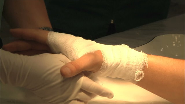 пациенту бинтуют руку в операционной