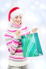 Santa girl holding shopping bag on a light background