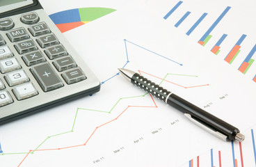 Obraz premium Pen and calculator on paper table with diagram