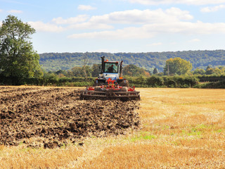 Tractor Ploughing over a field of Wheat stubble