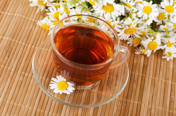 Glass cup with a camomile tea