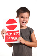 bambino sorridente mostra cartello proprietà privata