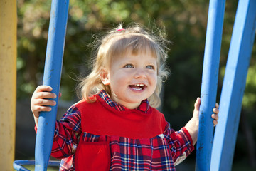 Adorable little girl having fun on a swing