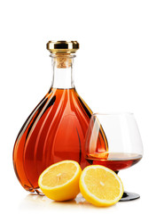 Cognac in bottles with glass and lemons