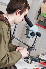 jeweller is working with  microscope