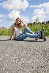 Inline skates young woman sitting asphalt road