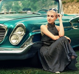 Beautiful lady sitting near retro convertible.