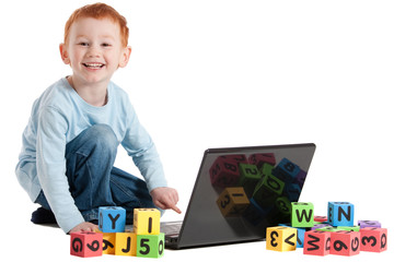 Boy child at school with computer and kids blocks