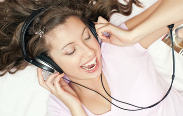 Радостная девушка слушает музыку в наушниках