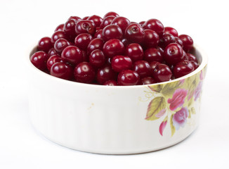 Bowl with ripe cherries. Isolated on a white background.