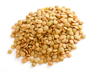 Brown lentils scattered on white background