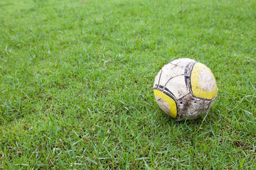Fototapeta na wymiar Old Soccer ball in Lawn