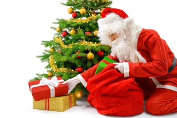Obraz na płótnie Canvas Weihnachtsmann legt Geschenke unter den Christbaum
