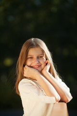 Naklejka premium girl sits propped on his head with his hands and smiling