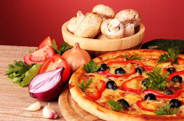 pizza and vegetables on red background
