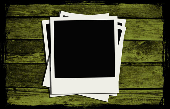Polaroid frames over abstract wooden background