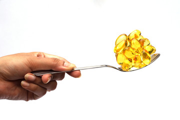 Cod liver oil pills in a spoon