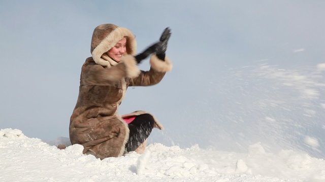 The woman is throwing up snow