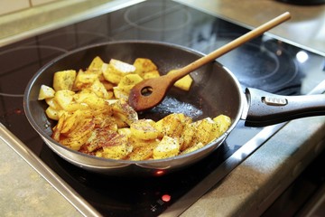 Bratpfanne mit Bratkartoffeln auf dem Herd