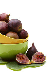 Fresh ripe figs and a juicy slice in color cups.
