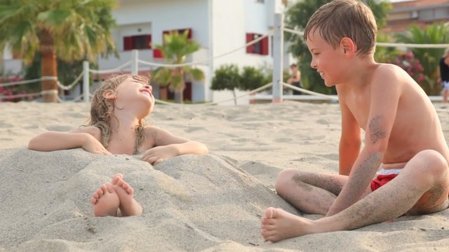 brother falls up with sand his sister tries stand up