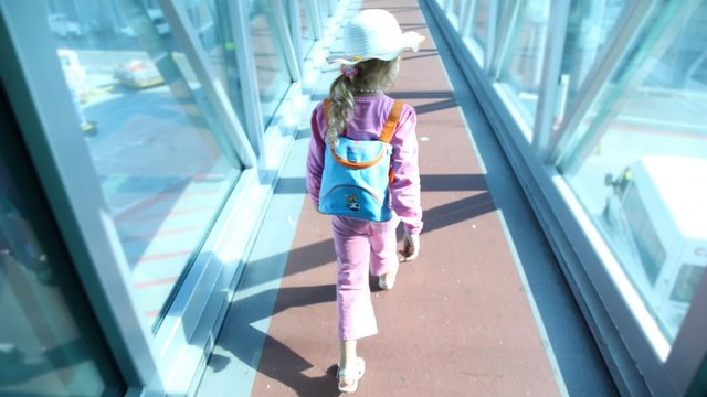 Girl goes on crossing with glass walls at airport