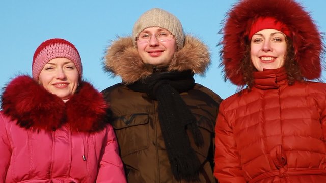 Two women and man standing outdoors at winter