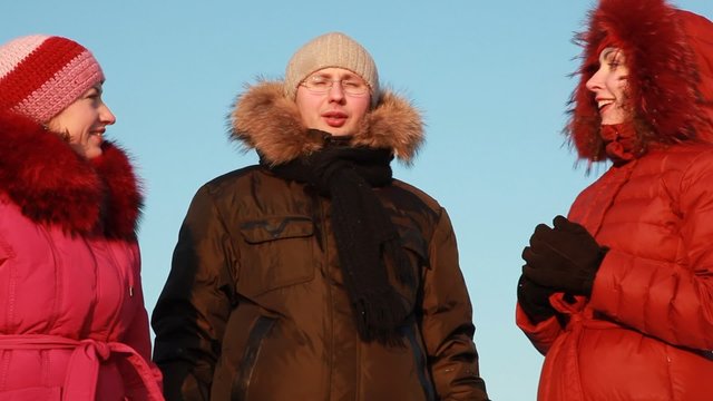 Two women and man standing outdoors at winter