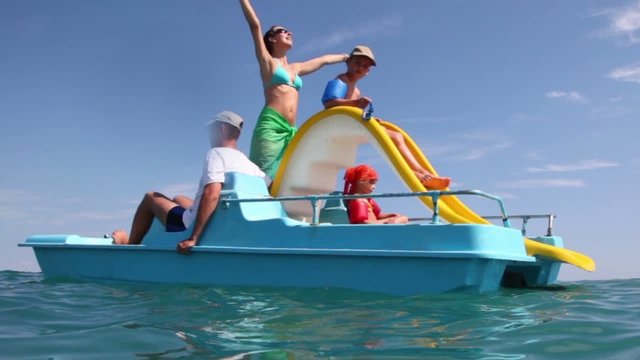 Father, mother and kids sailing on catamaran