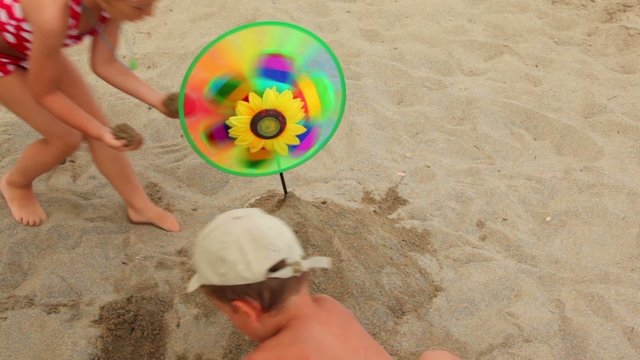 Children make mound of sand, where set toy that spins